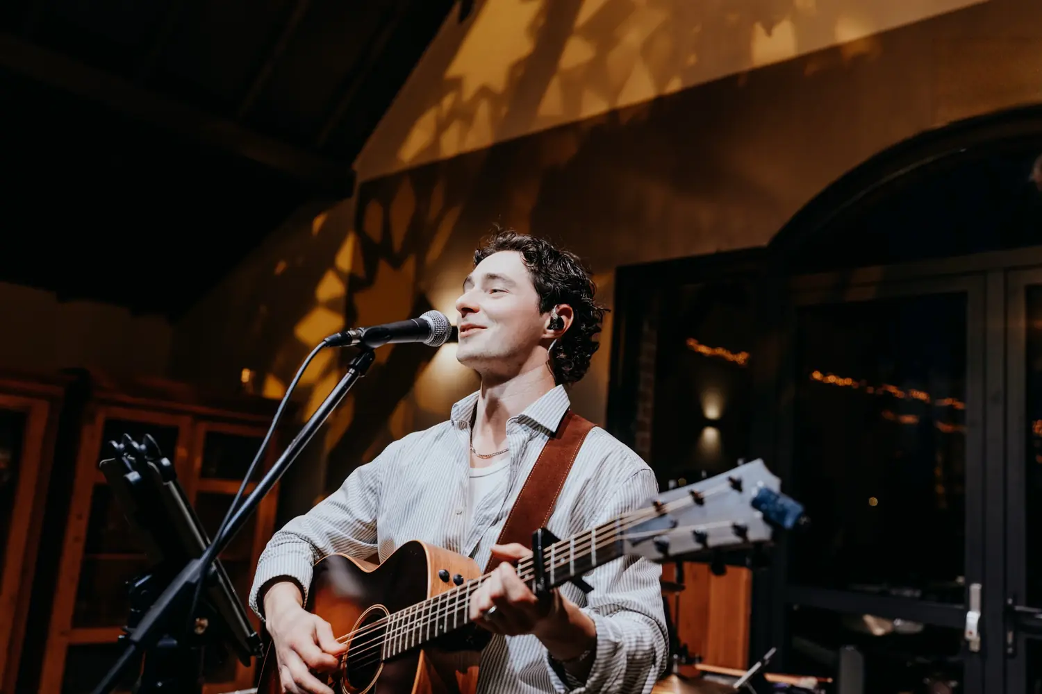Carl chante et joue de la guitare acoustique en salle